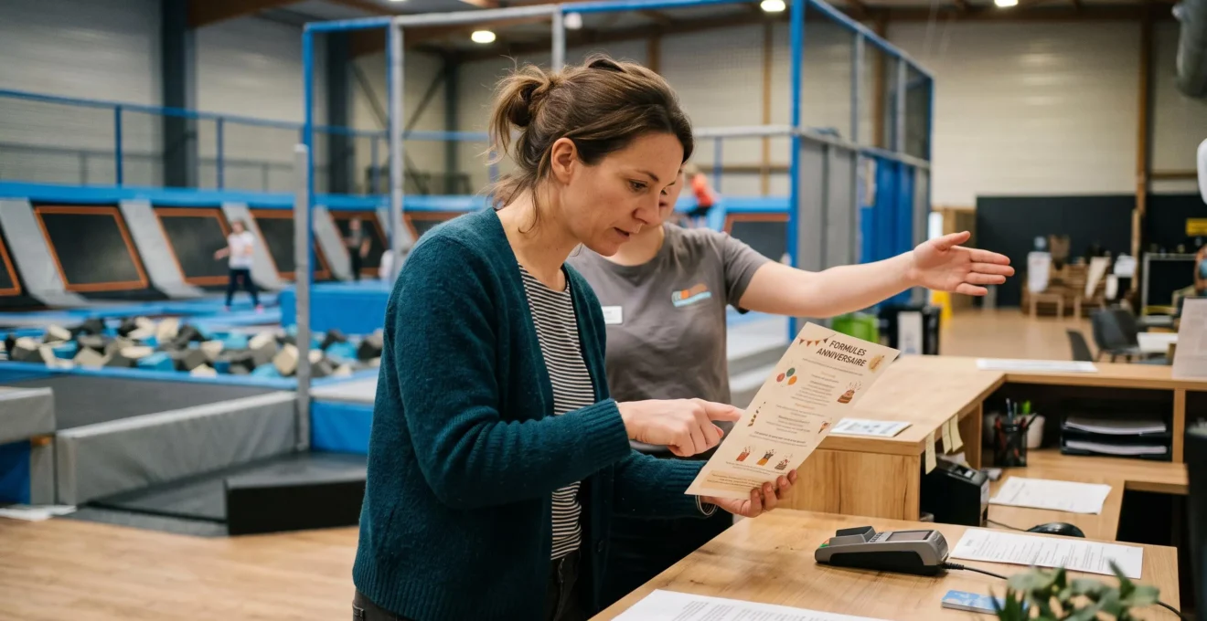 Une mère compare une brochure de formules d'anniversaire avec un employé à l'accueil d'un trampoline park.